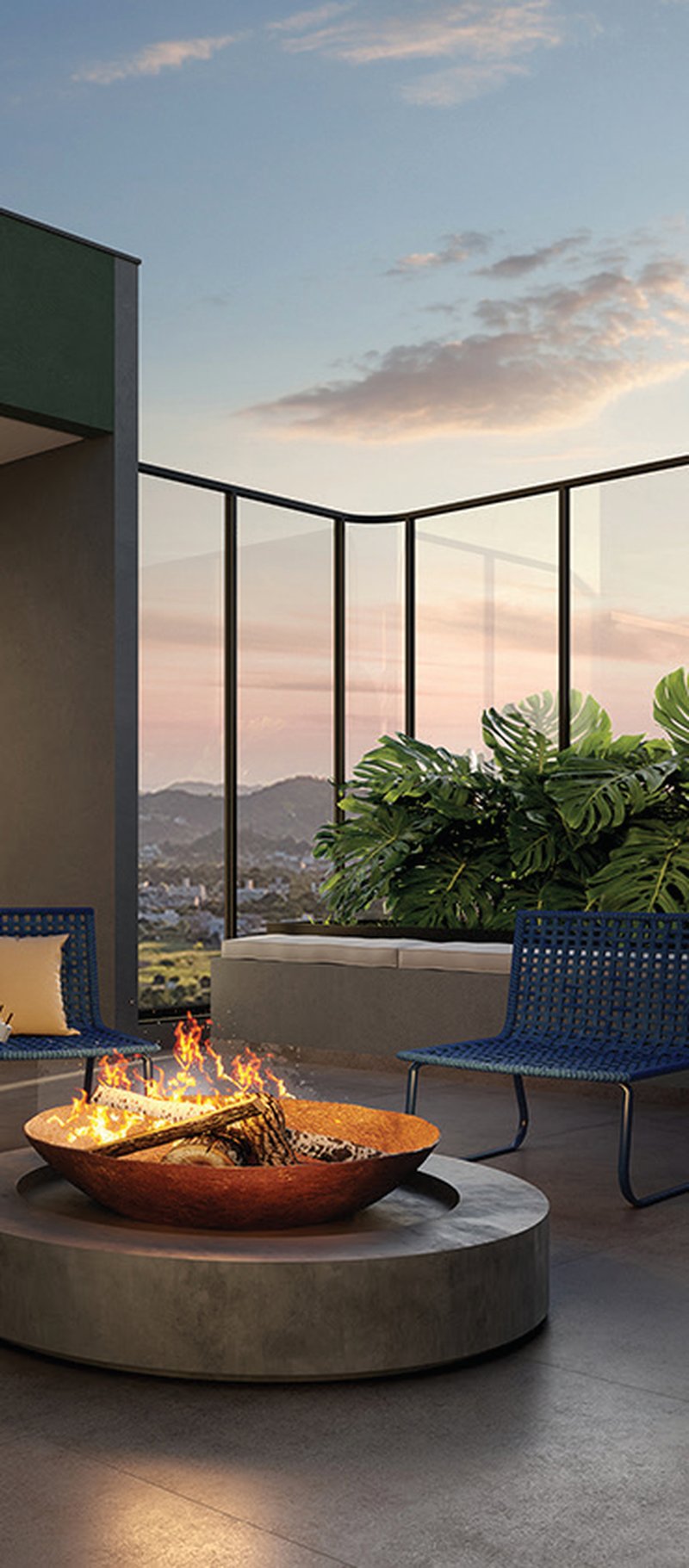 Rooftop do Elevvo ao entardecer, com fire place e vista para a cidade.