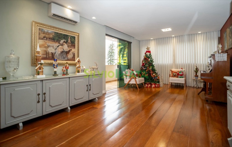 Sala de estar ampla do apartamento no Residencial Pablo Picasso, com piso de madeira e decoração de Natal.